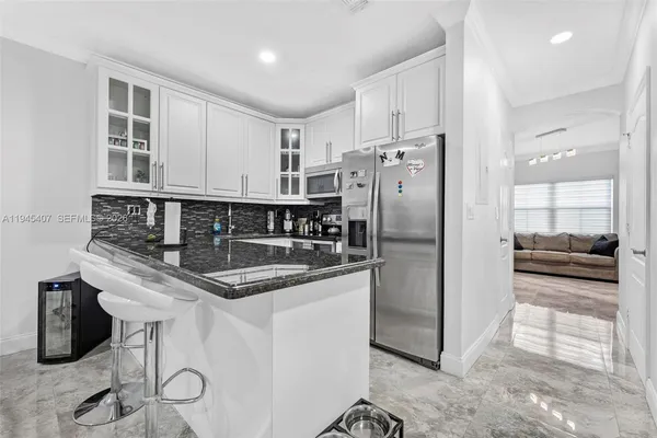 a kitchen with stainless steel appliances granite countertop a sink a stove and a refrigerator