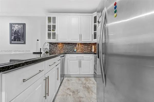 a kitchen with granite countertop a sink and cabinets
