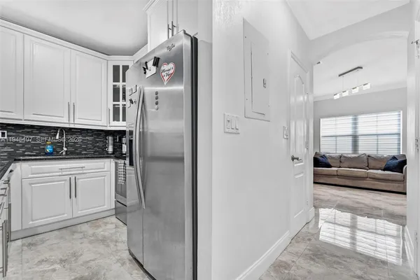 a kitchen with stainless steel appliances granite countertop a refrigerator a stove and white cabinets