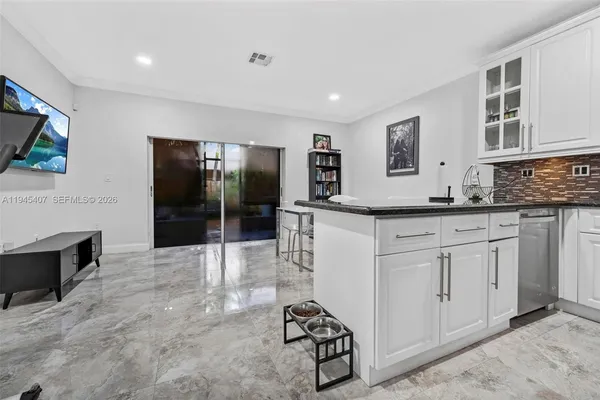 a kitchen with stainless steel appliances kitchen island granite countertop a stove a sink and a refrigerator