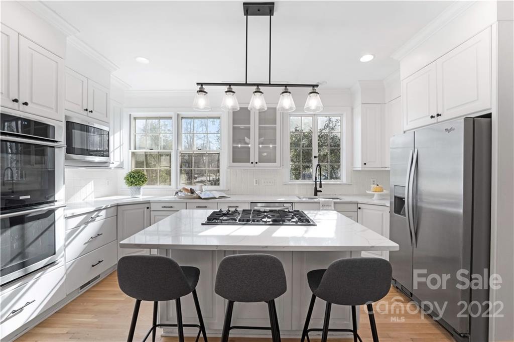 2026 South Wendover Road Charlotte, NC 28211 - Photo 4 of 31 a kitchen with stainless steel appliances granite countertop a stove a refrigerator a sink a stove and white cabinets with wooden floor