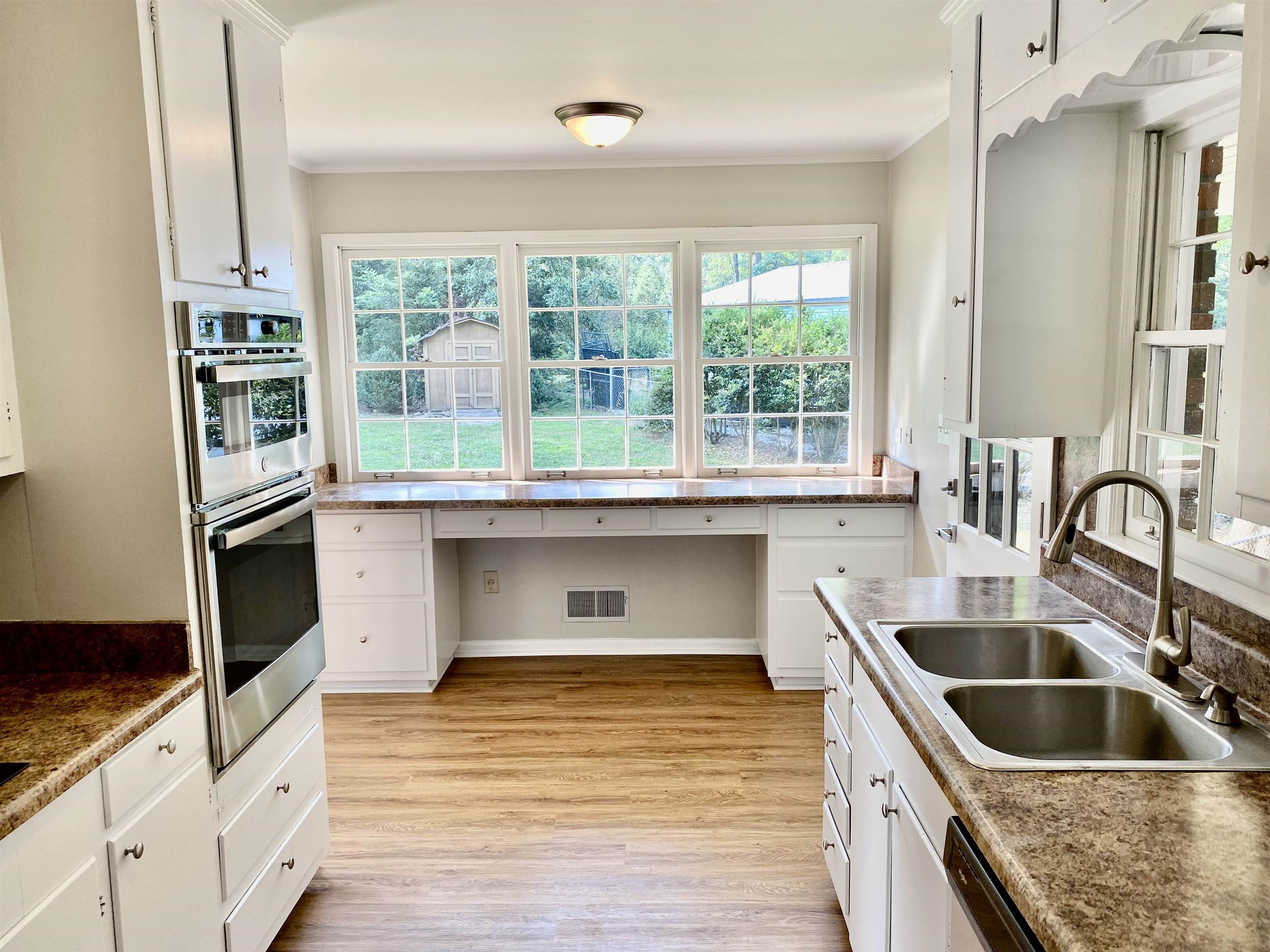16 Jefferson Drive Rome, GA 30165 - Photo 3 of 26 a kitchen with kitchen island a sink wooden floor and a large window