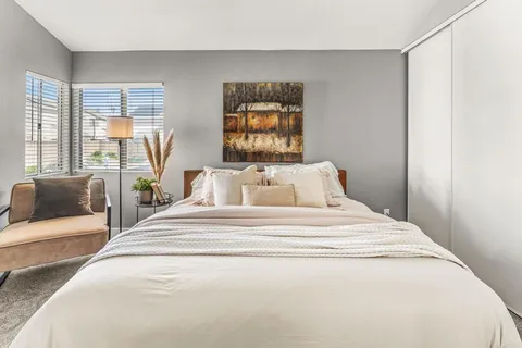 a spacious bedroom with a bed and glass windows