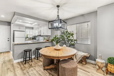 a kitchen with stainless steel appliances a dining table chairs and chandelier