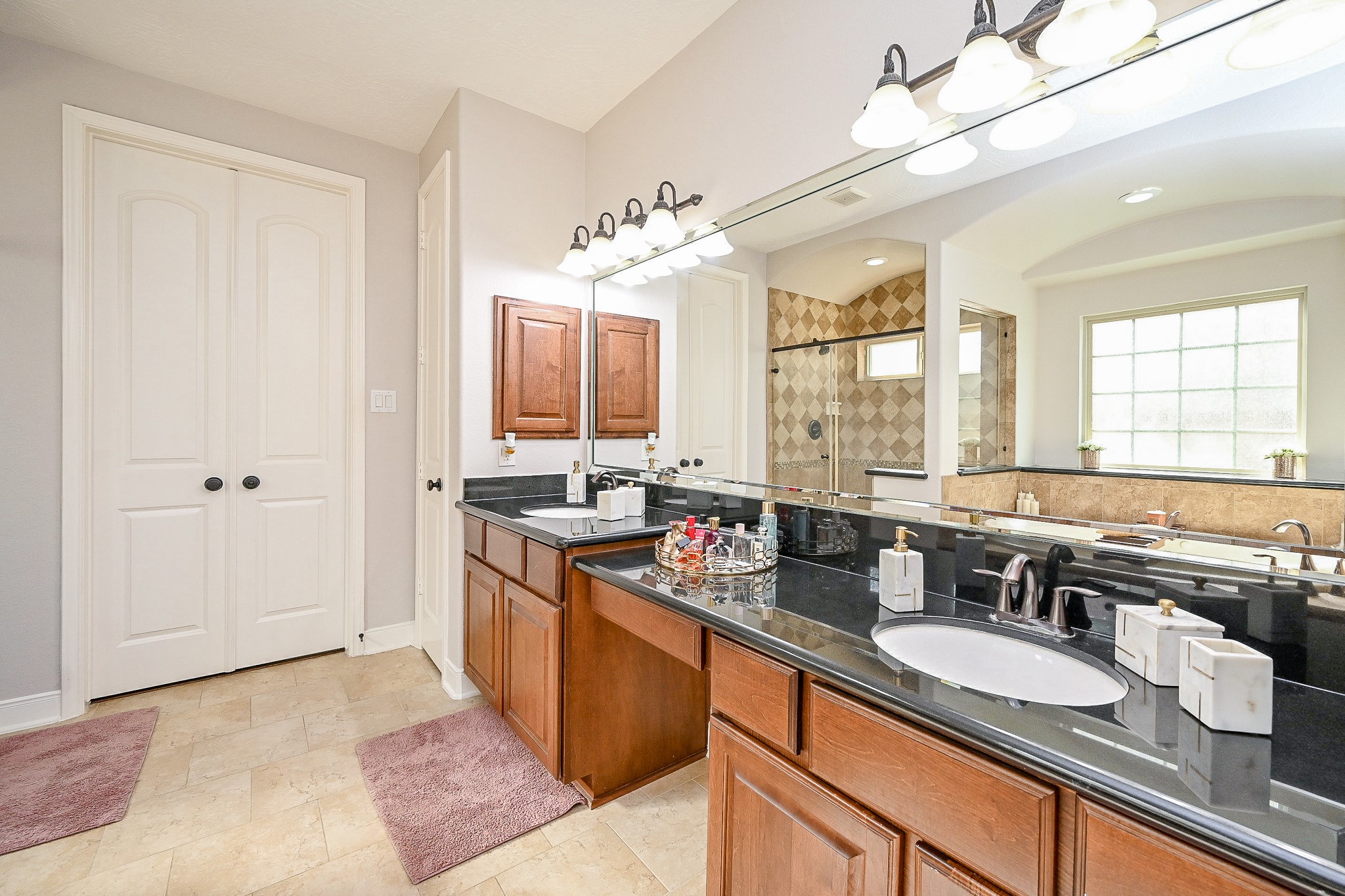 17607 Astrachan Road Richmond, TX 77407 - Photo 26 of 50 a large bathroom with a granite countertop double vanity sink a mirror and a bathtub