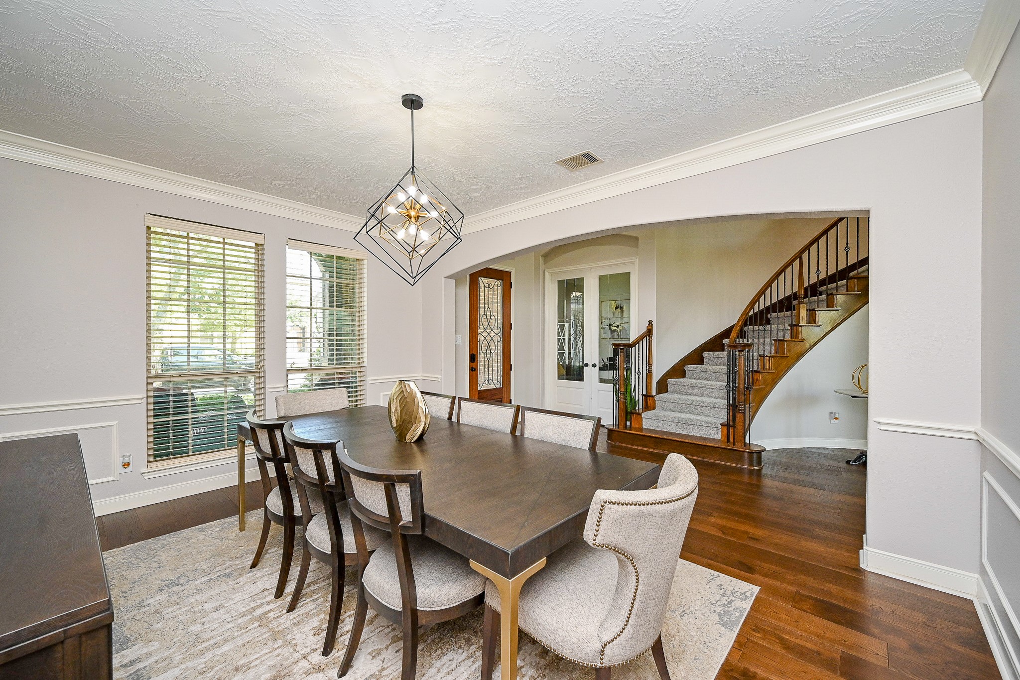 17607 Astrachan Road Richmond, TX 77407 - Photo 10 of 50 a dining room with wooden floor a chandelier a wooden table and chairs