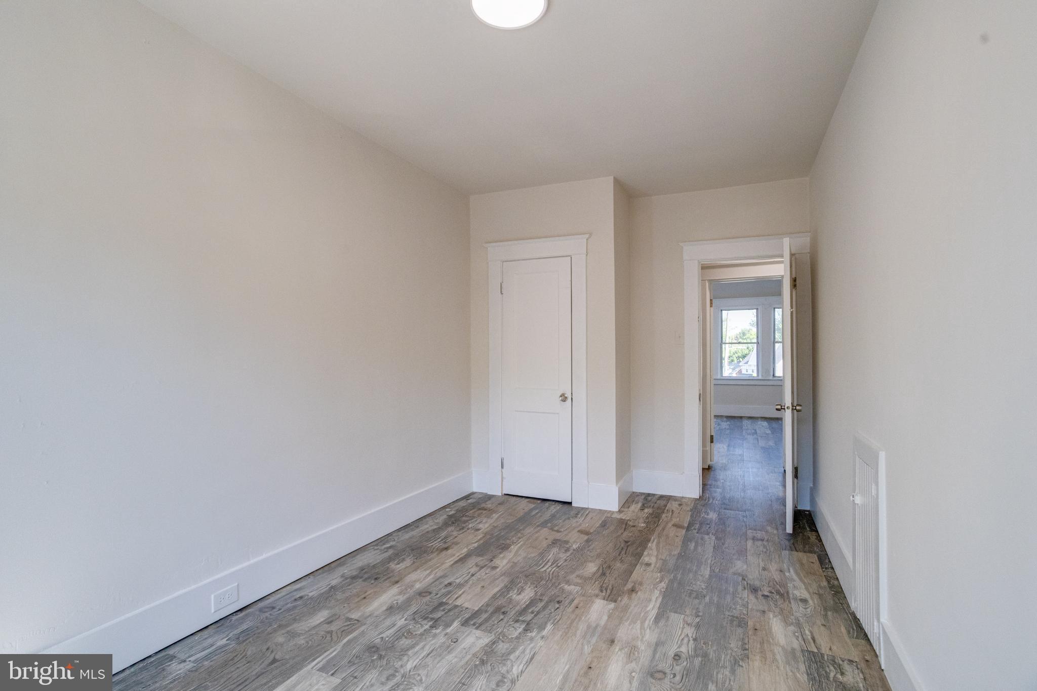 5878 Belair Road Baltimore, MD 21206 - Photo 26 of 41 an empty room with wooden floor and windows