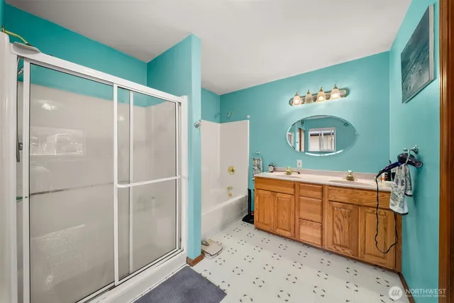 a bathroom with a sink mirror and a shower