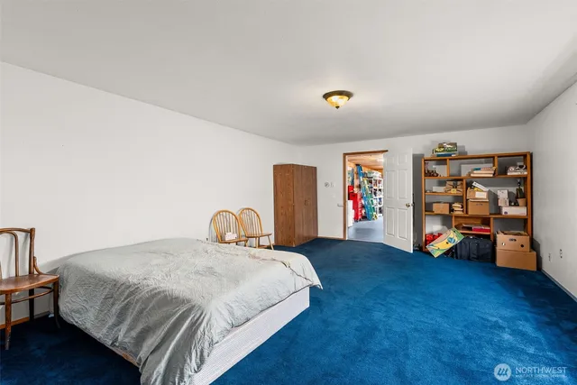 a spacious bedroom with a bed and a wooden floor