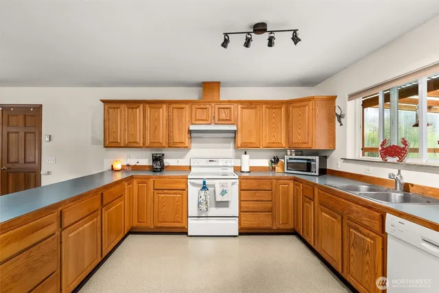 a kitchen with stainless steel appliances a sink window and cabinets