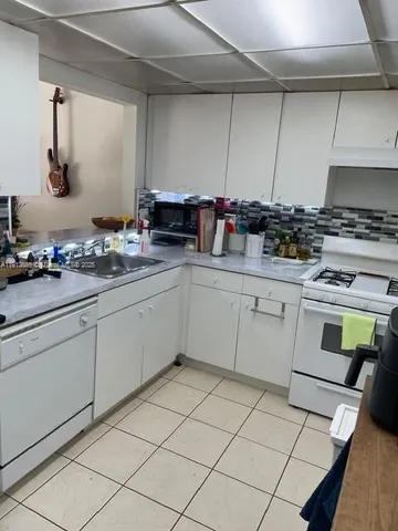 a kitchen with a stove a sink and a cabinets