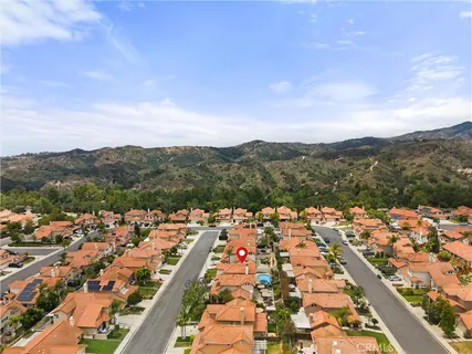 an aerial view of residential houses with outdoor space and trees