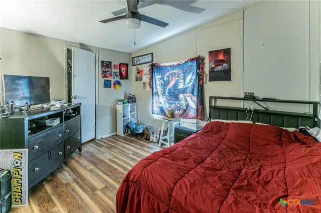 a bedroom with a bed and a flat tv screen on dresser