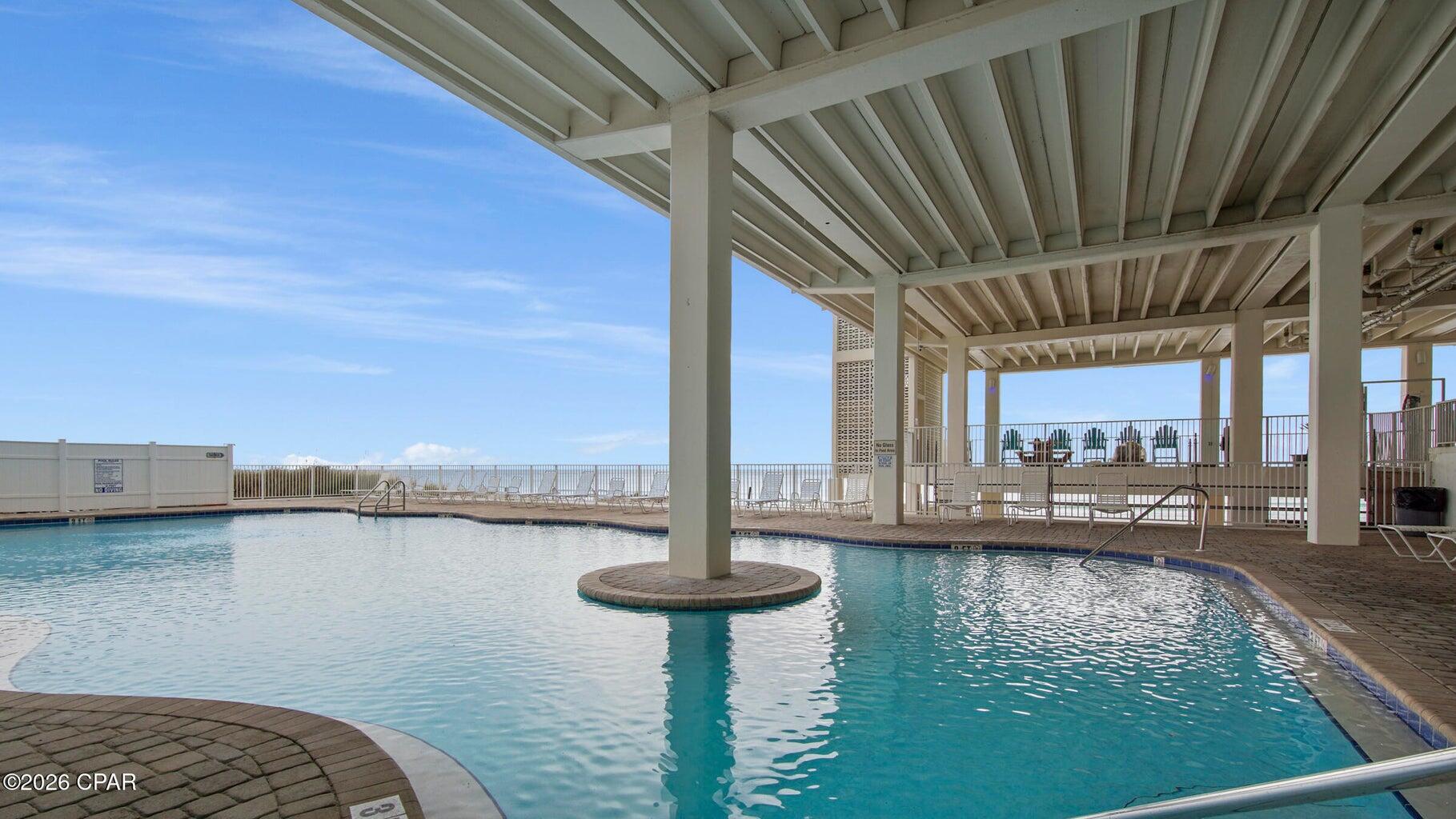 14401 Front Beach Road, Unit 221 Panama City Beach, FL 32413 - Photo 17 of 20 a view of swimming pool with a table and chairs