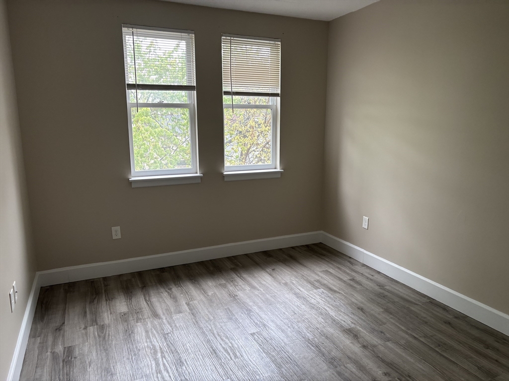 34 Sumner Avenue, Unit 301 Springfield, MA 01108 - Photo 4 of 8 an empty room with wooden floor and windows