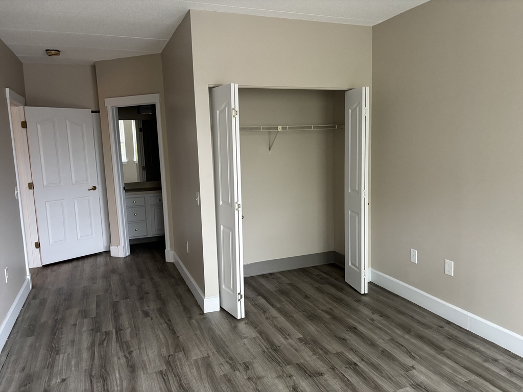 34 Sumner Avenue, Unit 301 Springfield, MA 01108 - Photo 7 of 8 an empty room with wooden floor & closet area