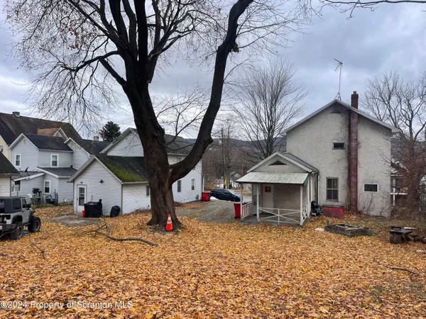 a view of a house with a yard covered in snow