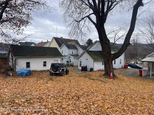 a view of a house with backyard and a tree