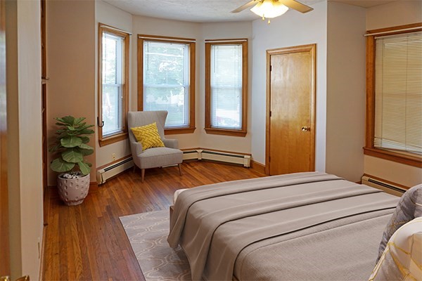 85 Brown Street, Unit 1 Waltham, MA 02453 - Photo 3 of 7 a bedroom with a bed and wooden floor