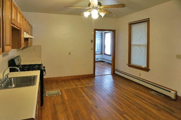 85 Brown Street, Unit 1 Waltham, MA 02453 - Photo 6 of 7 a view of a livingroom with wooden floor and a ceiling fan