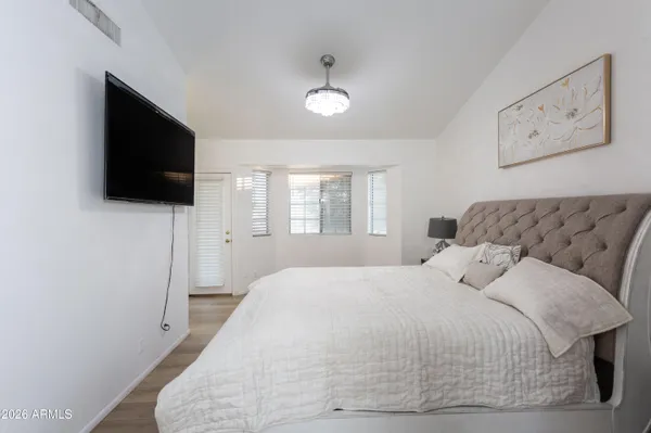 a bedroom with a large bed and a flat screen tv