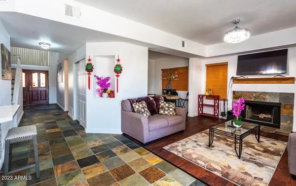 a living room with furniture a flat screen tv and a fireplace