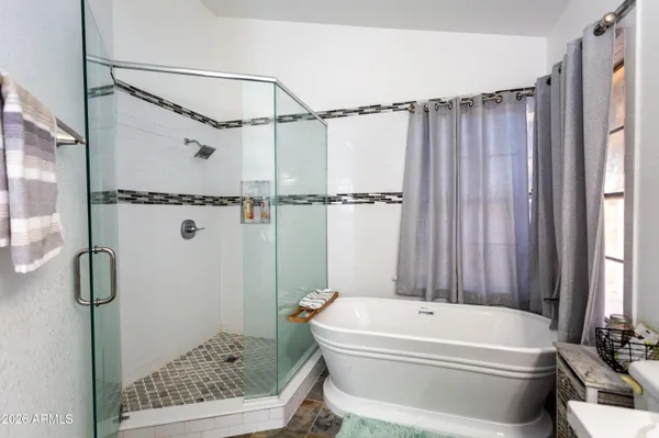 a bathroom with a tub a window and a shower