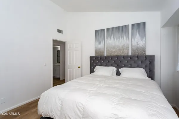 a large white bed in a room next to a window