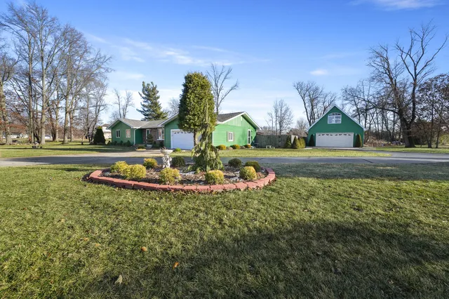 a view of a house with a yard and a fountain