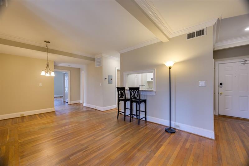 a view of a room with wooden floor kitchen chandelier and glass door