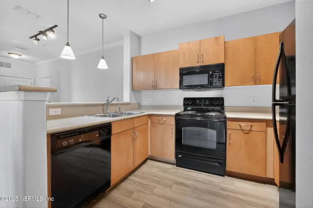 a kitchen with stainless steel appliances a stove a sink and a refrigerator