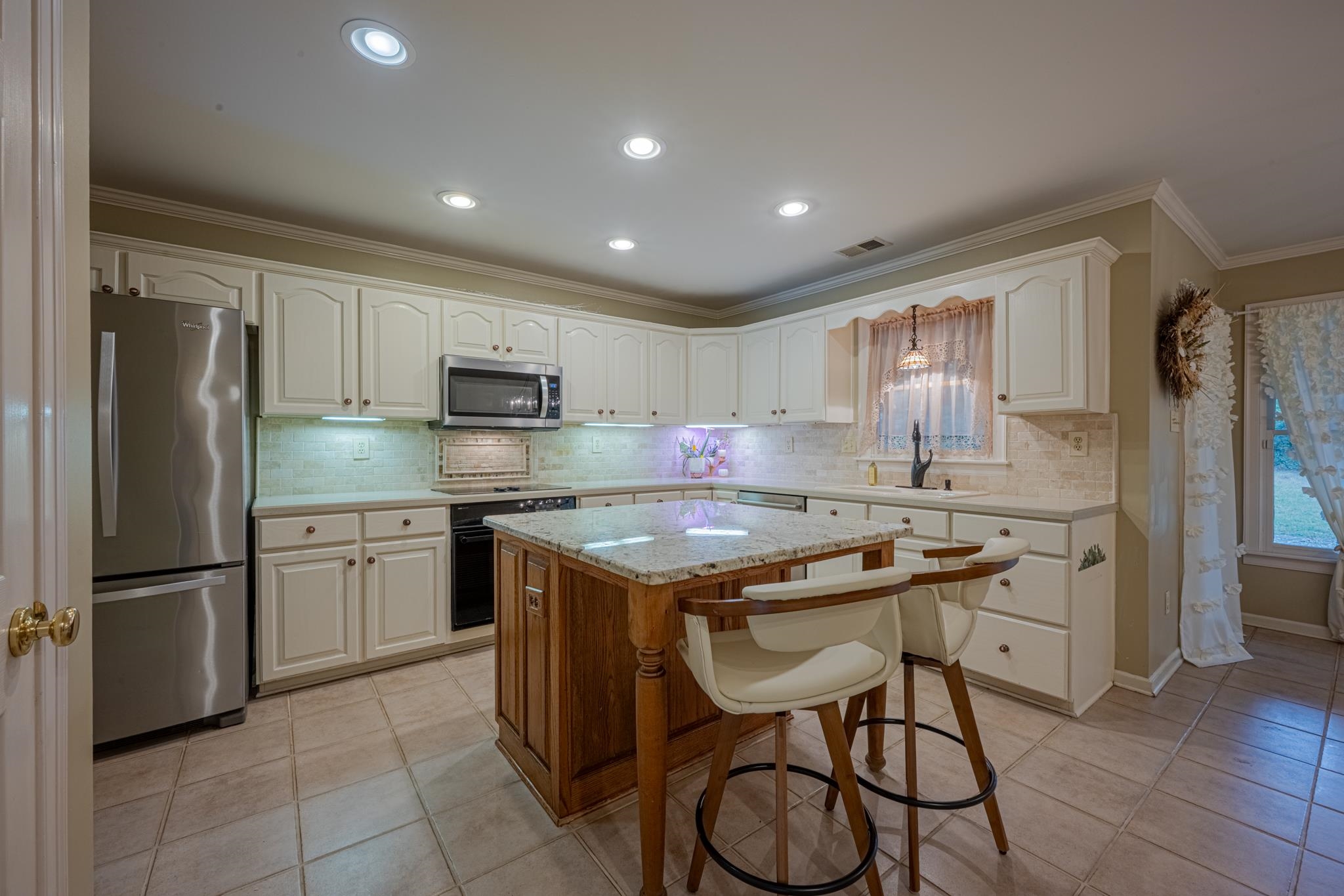 8805 River Rise Drive Memphis, TN 38016 - Photo 11 of 40 a kitchen with kitchen island granite countertop stainless steel appliances a sink a stove a refrigerator cabinets and dining table