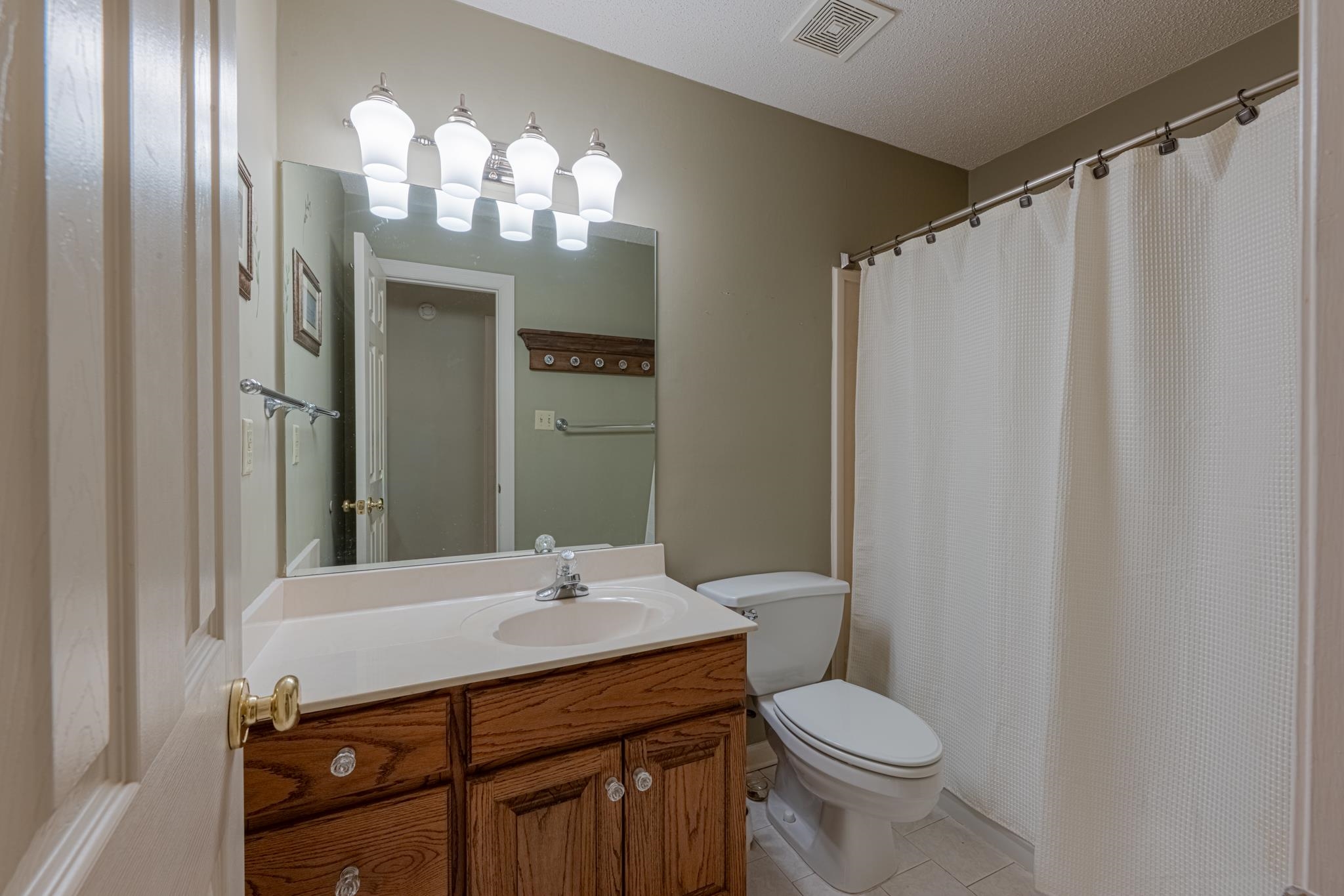 8805 River Rise Drive Memphis, TN 38016 - Photo 26 of 40 a bathroom with a sink vanity mirror and toilet