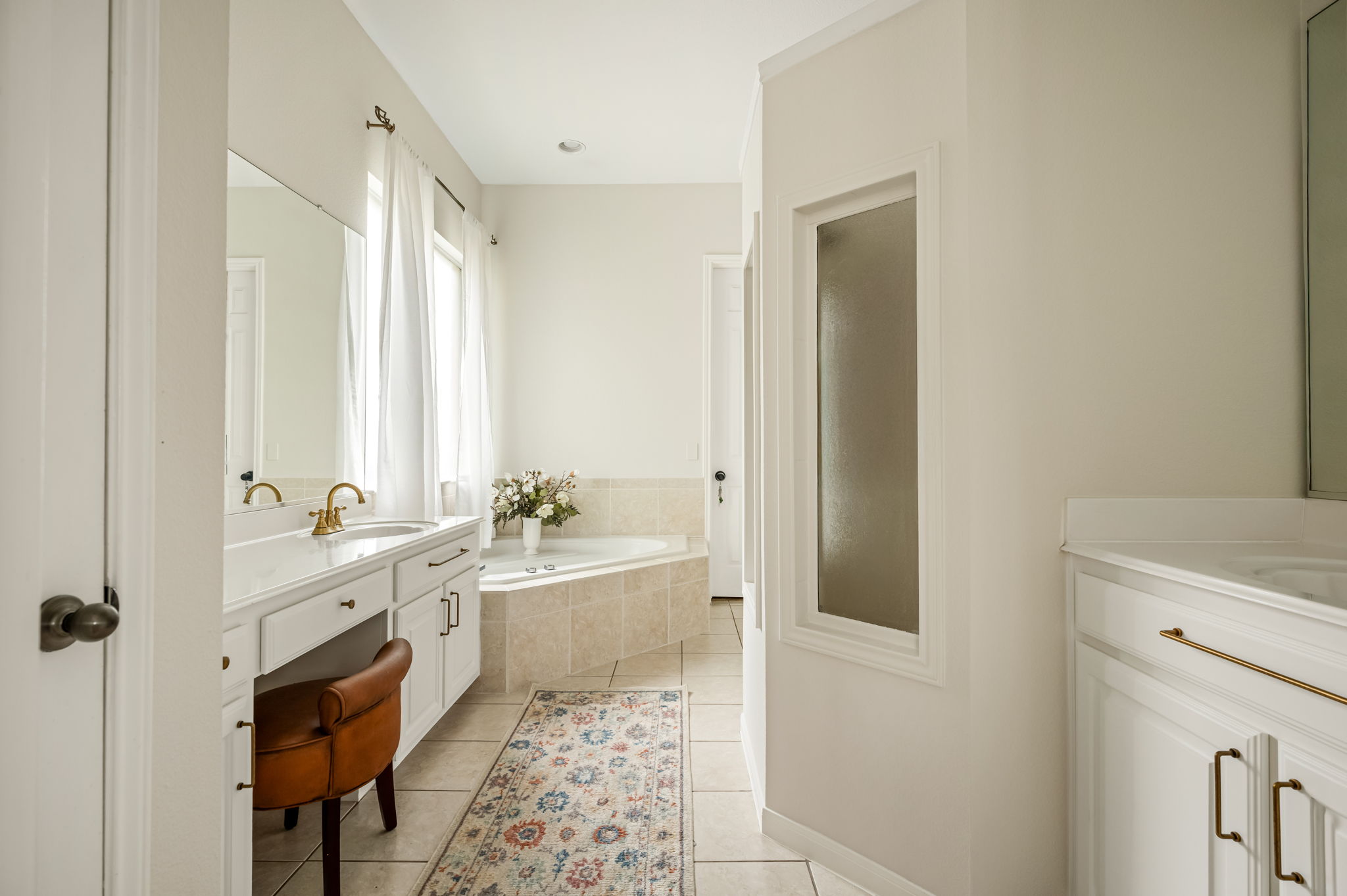 10804 Ariock Lane Austin, TX 78739 - Photo 14 of 32 a bathroom with a double vanity sink a mirror and a bathtub
