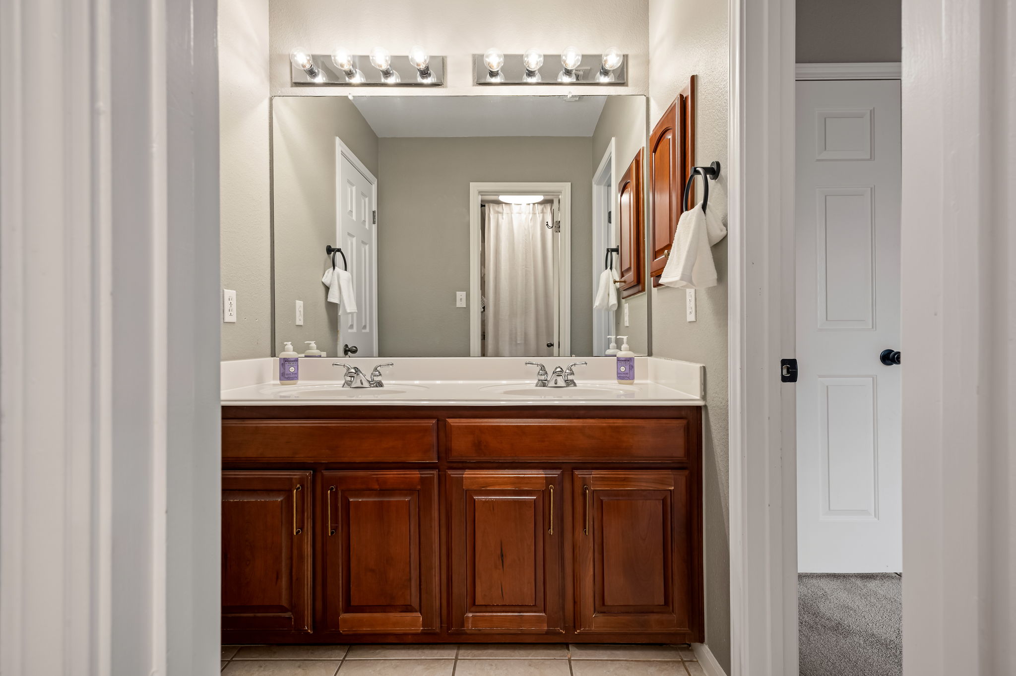 10804 Ariock Lane Austin, TX 78739 - Photo 21 of 32 a bathroom with a double vanity sink and a mirror