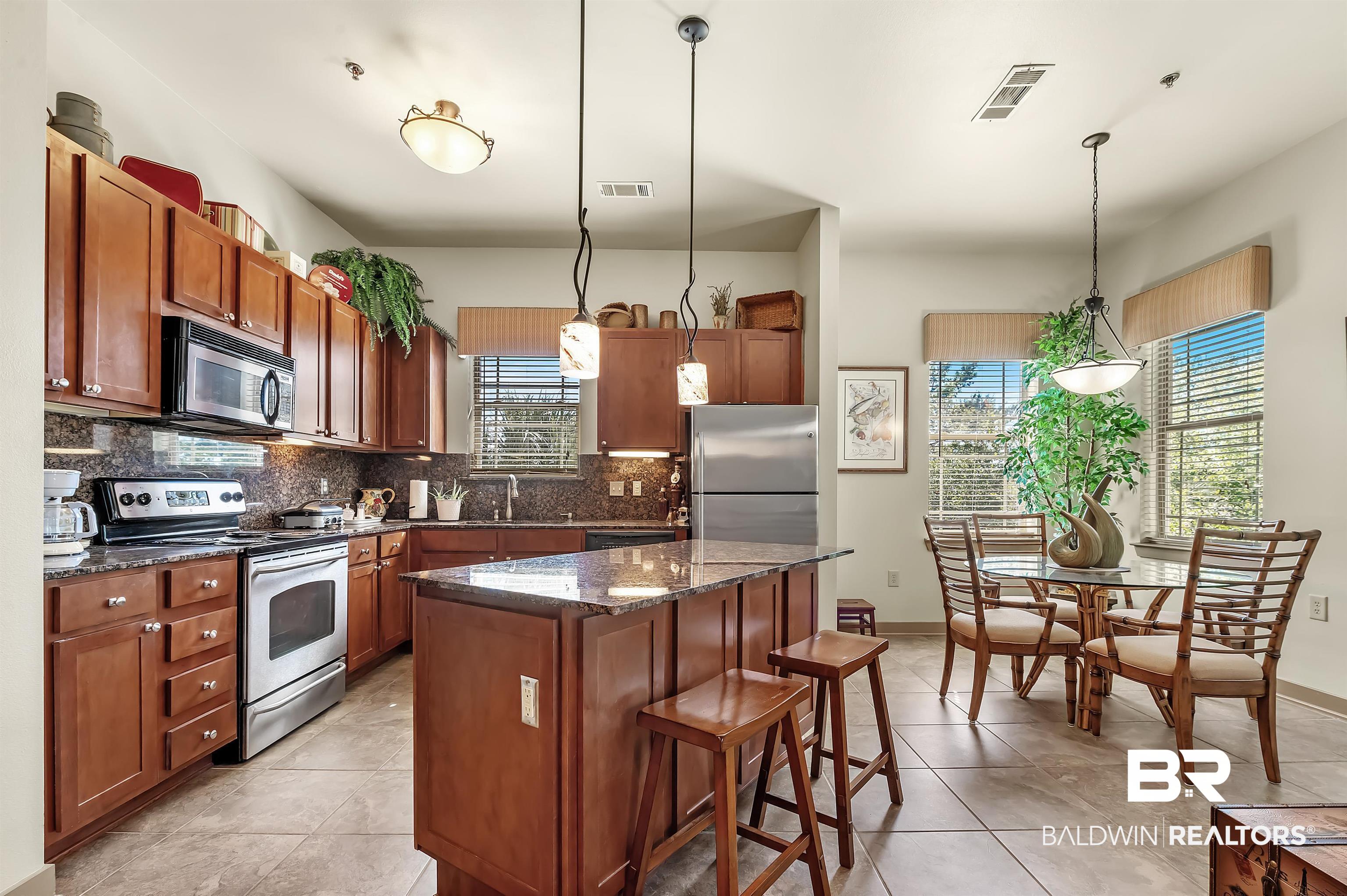 1430 Regency Road, Unit A301 Gulf Shores, AL 36542 - Photo 11 of 47 Kitchen with a kitchen island, appliances with stainless steel finishes, pendant lighting, and backsplash