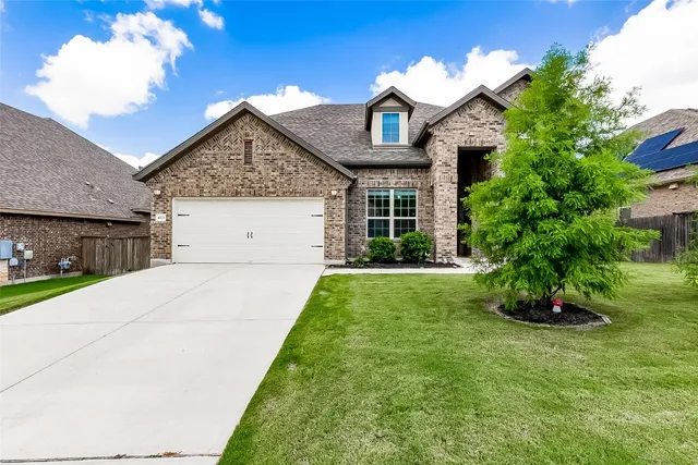a front view of a house with a yard and potted plants