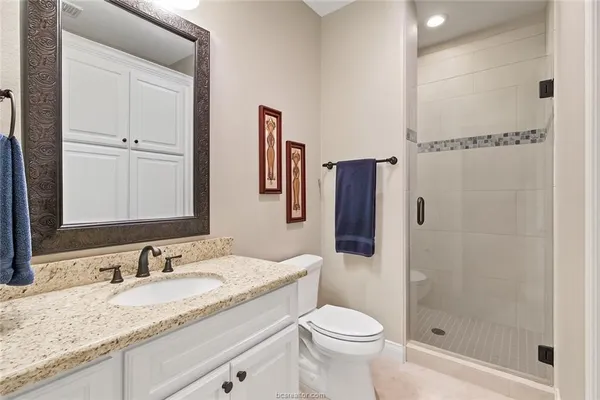 a bathroom with a granite countertop sink toilet and shower