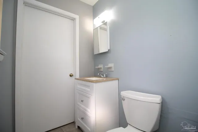 a bathroom with a toilet a sink and mirror