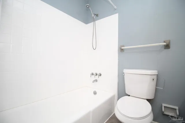 a white toilet sitting next to a bathroom sink and tub