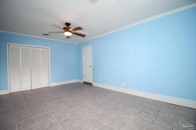 an empty room with a window and a fan