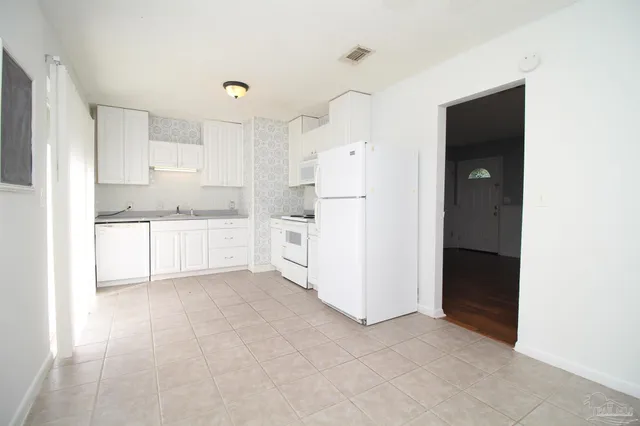 a kitchen with white cabinets and white appliances