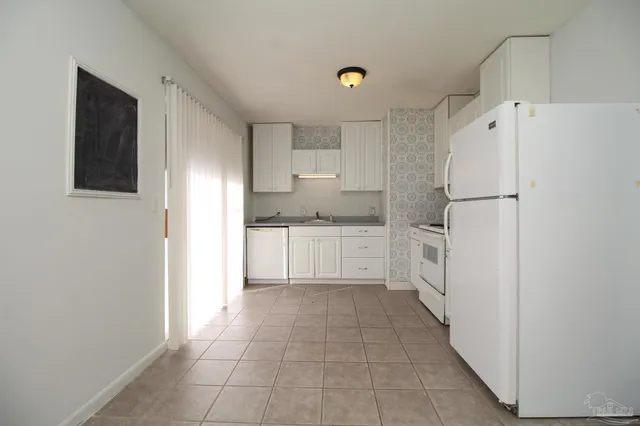 a kitchen with white cabinets and white appliances