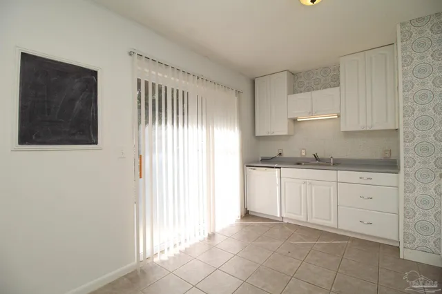 a kitchen with granite countertop white cabinets and stainless steel appliances