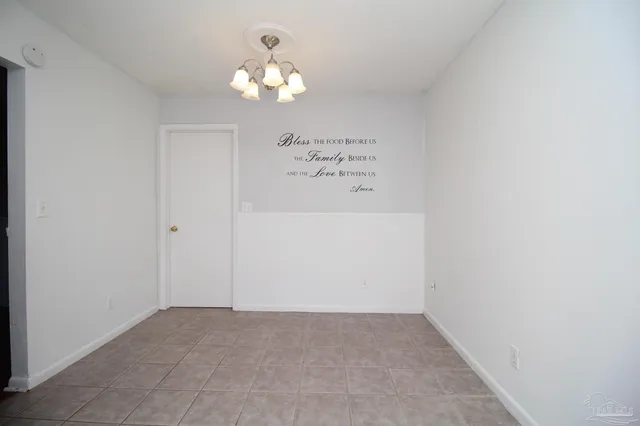 an empty room with a chandelier fan