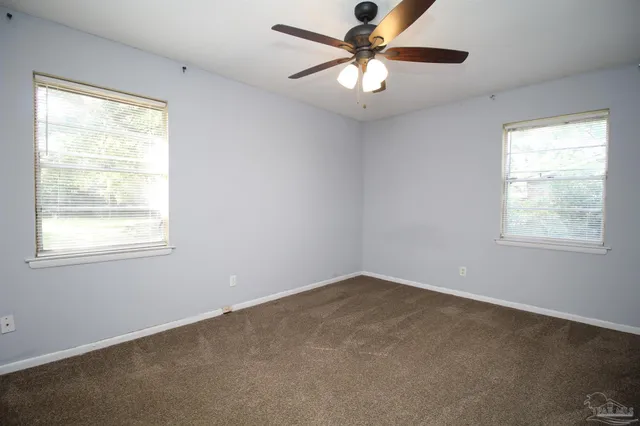 an empty room with a window and a fan