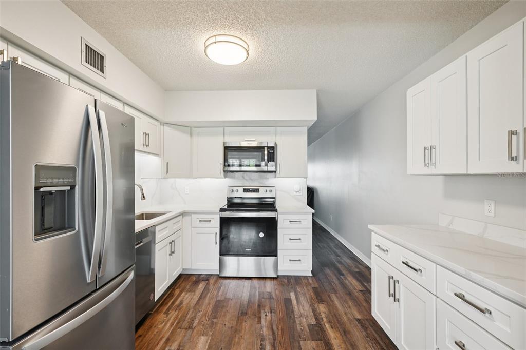 a kitchen with stainless steel appliances a stove sink and refrigerator