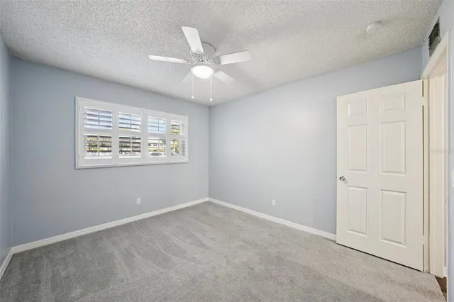an empty room with a window and a fan