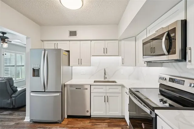 a kitchen with stainless steel appliances a refrigerator stove and microwave
