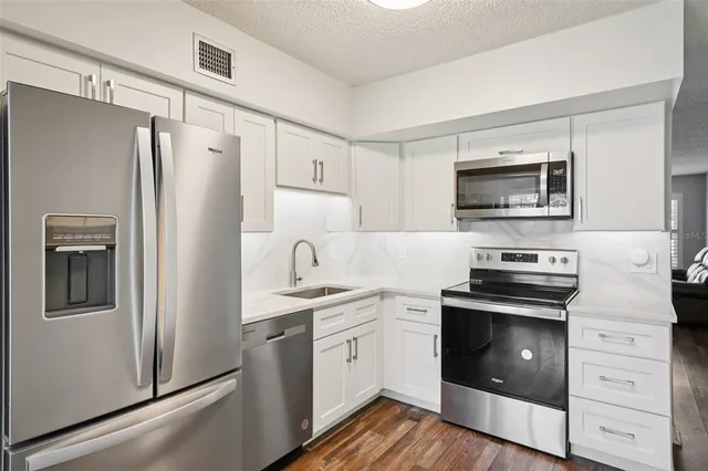 a kitchen with white cabinets and stainless steel appliances